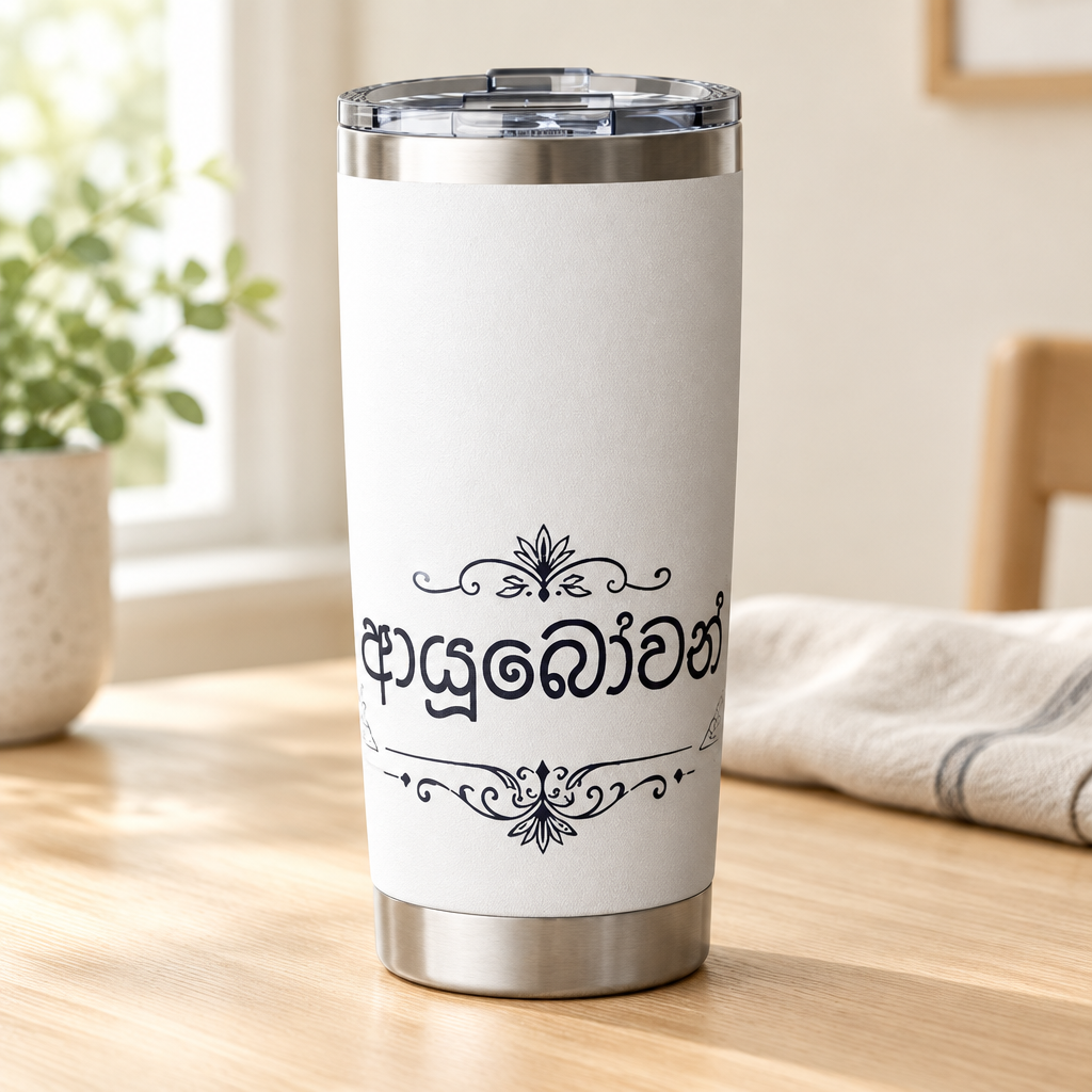 White tumbler with Sinhala lettering and black ornamental design on a light timber table in a bright home — Ceylon Culture Vibes