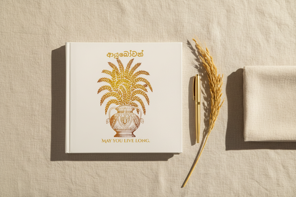 Ayubowan hardcover photo book flat lay with dried paddy stem and gold pen — Ceylon Culture Vibes